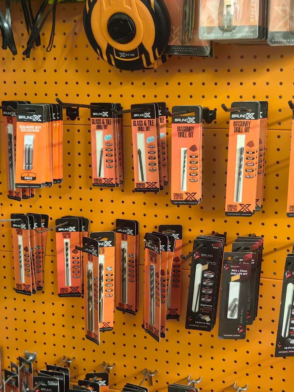 Drill bits and hardware tools displayed on a pegboard